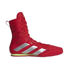 A red high-top boxing shoe by Adidas, featuring three silver stripes on the side, a textured knit upper, and a bright neon yellow-green outsole edge, shown against a plain light gray background.